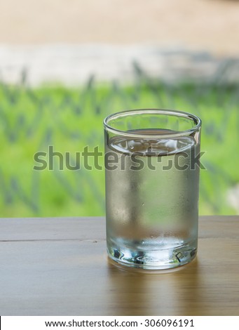 Take a glass of water in a vertical wooden floor behind the green focal glasses blur and poor light.
