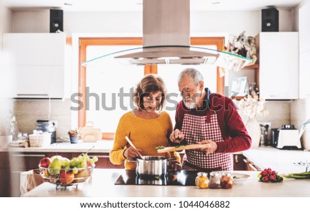 Similar – Image, Stock Photo Couple preparing food in kitchen.