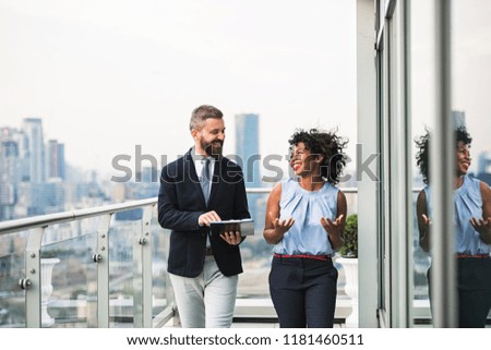 A portrait of two businesspeople standing against London view panorama.