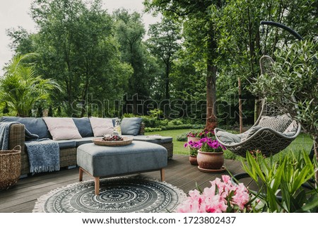 Mobiliario clásico en terraza de madera en un jardín verde y bonito