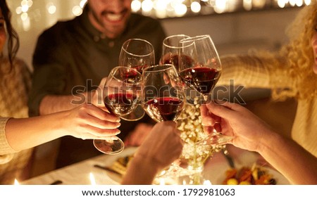 vacances, célébration et concept de personnes - amis heureux qui dînent à la maison pour noël boire du vin rouge non alcoolisé