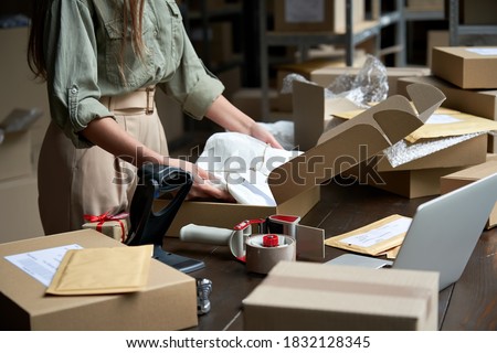 Closeup view of female online store small business owner seller entrepreneur packing package post shipping box preparing delivery parcel on table. Ecommerce dropshipping shipment service concept. Photo stock © 