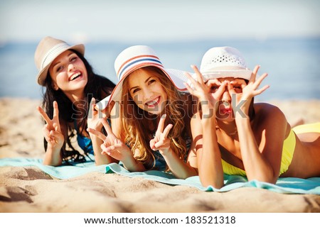 Similar – Foto Bild Lächelnde Freundinnen mit Hüten unterhalten sich auf einem Holzzaun am Strand sitzend