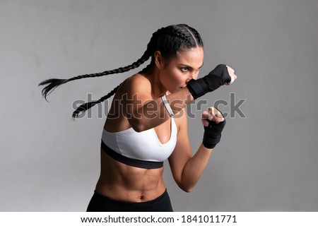 Foto Bild Starke ethnische Sportlerin trainiert an einem Trainingsgerät in einem modernen Fitnessstudio