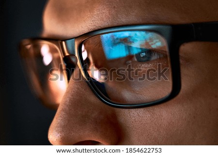 Close up view of focused businessman wears computer glasses for reducing eye strain blurred vision looking at pc screen with computer reflection using internet, reading, watching, working online late. ストックフォト © 