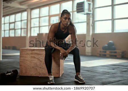 Similar – Image, Stock Photo Serious black sportswoman sitting on stone border in city