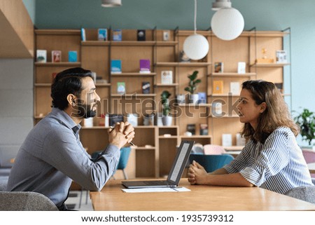 Indian male hr specialist manager, employer, boss listening female latin candidate at job interview, consulting client at office meeting. Hiring and employment, human resources, recruitment concept. Stock foto © 