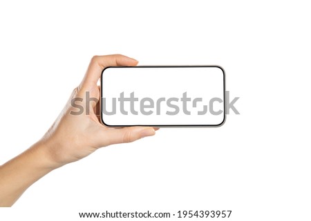 Female hand holding mobile smart phone with blank screen. Hand holding smartphone screen horizontally against white background. Close up of woman hand holding cellphone isolated on white background.