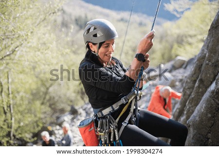 Foto Bild Ältere Frau klettert auf felsigen Klippen gegen den Himmel