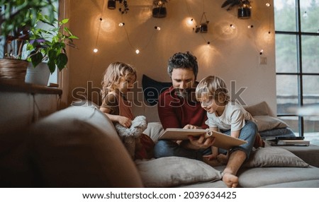 Similar – Foto Bild Vater mit zwei, kleinen Kindern in Badehose und roten T-Shirts, stehen am Meer und beobachten eine Welle des Wassers, welche in ihre Sandburg am Strand spült. Die Familie hält Schaufel und Werkzeug in den Händen und staunen neugierig über das Wasserpiel.