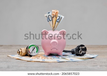 Sad piggybank for high cost of gas, electricity and power. Inflation is increasing everywhere, especially for gas and electricity bills. Saving and spending money due to power crisis. Foto d'archivio © 