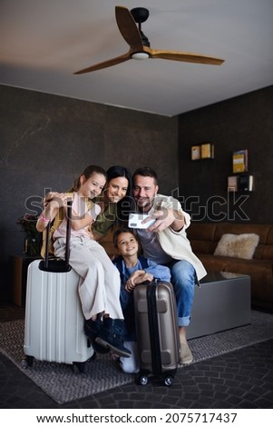 Feliz familia joven con dos niños tomándose selfie en un hotel de lujo, vacaciones de verano.