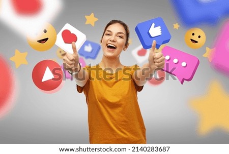 concept des médias sociaux, des blogs et des gens - jeune femme souriante heureuse ou adolescente en t-shirt orange, avec des pouces sur fond gris