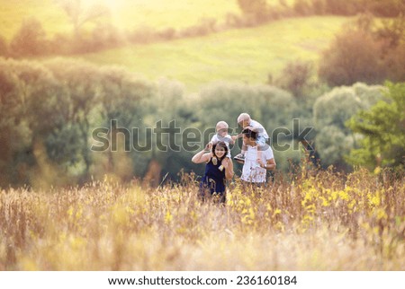 Feliz familia disfrutando de la vida juntos en el prado al aire libre.