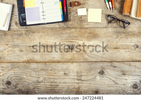 Mezcla de material de oficina sobre un fondo de mesa de madera. Vista desde arriba.
