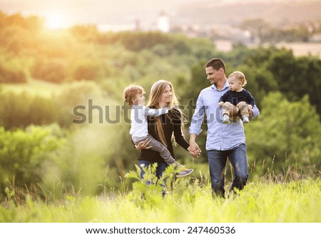 Felices familias que pasan tiempo juntos en la naturaleza verde.