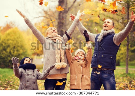 família, infância, temporada e conceito de pessoas - família feliz jogando com folhas de outono no parque