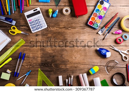 Desk with stationary and with Back to school sign. Studio shot on wooden background.