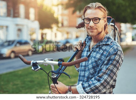 Portrait of blonde white man in the city with a bike