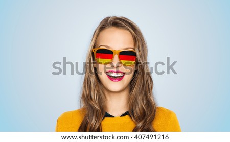 people, patriotism and nationality  concept - happy young woman or teen girl face in sunglasses with german flags over blue background ストックフォト © 