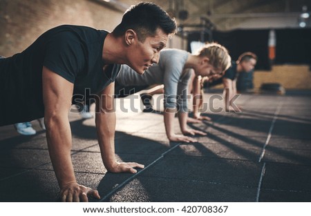 Fit young people doing pushups in a gym looking focused Stock fotó © 