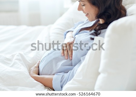 Similar – Image, Stock Photo Smiling pregnant woman touching belly on floor at home