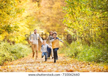 Família jovem bonita em uma caminhada na floresta de outono.