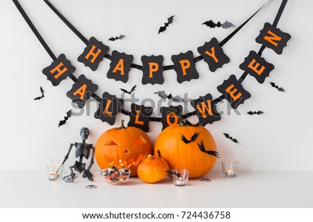 halloween, festividades y concepto de decoración - calabazas talladas con caramelos y guirnaldas festivas sobre fondo blanco