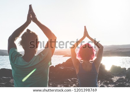 Similar – Image, Stock Photo Focused couple doing yoga in Awkward pose in park