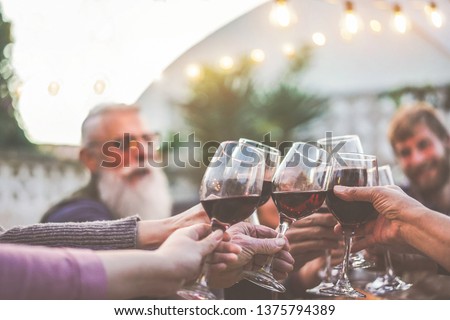 Felices fiestas familiares de moda animadas con vino tinto en la cena de barbacoa al aire libre - Diferente edad de la gente divirtiéndose en la comida del domingo - Comida, sabor y concepto de verano - Enfoque en las manos de las personas mayores