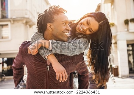Jóvenes parejas africanas divirtiéndose caminando por la ciudad - Enfoque en la cara del hombre