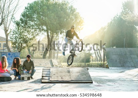 Image, Stock Photo Multiracial bikers jumping on trial bikes during workout above walkway