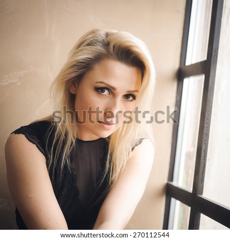 sexy beautiful blond young woman with natural make-up posing in the interior