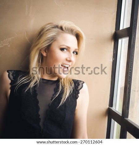 sexy beautiful blond young woman with natural make-up posing in the interior