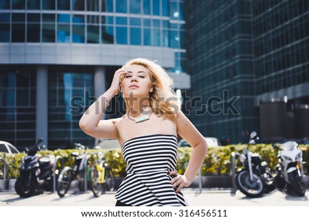 close-up portrait of a beautiful charming girl hipster blonde  laughing and posing with full lips against the backdrop of motorcycles