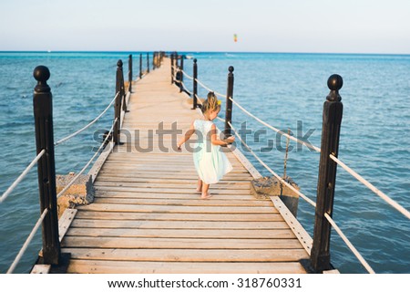 close-up portrait of a little girl child on holiday on the sea in a shiny dress