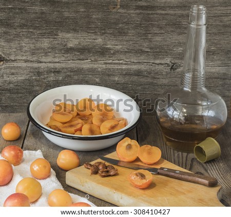 Plums are in the white bowl. Plums cut in half. Ripe plums lying on a wooden table. Still life with yellow plums.