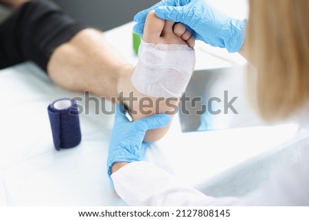 Doctor hand touches and examines wound on leg. Medical concept Foto d'archivio © 