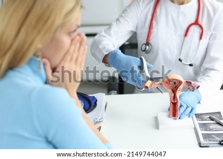 Doctor climbing fallopian tube with scissors onto artificial models on uterus and ovaries in clinic. Infertility obstruction of fallopian tubes concept Photo stock © 