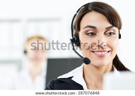 Call center service operators at work. Portrait of smiling pretty female helpdesk employee with headset at workplace. Effective and efficient business information, help and support concept