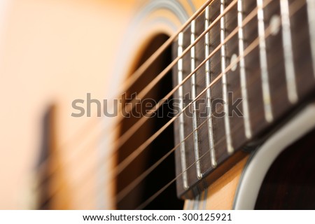 Classic acoustic guitar at weird and unusual perspective closeup. Six strings, free frets, sound hole and soundboard. Musical instruments shop or learning school concept