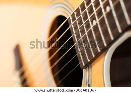 Classic acoustic guitar at weird and unusual perspective closeup. Six strings, free frets, sound hole and soundboard. Musical instruments shop or learning school concept