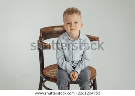 Similar – Image, Stock Photo 4 year old blonde girl with a brightly colored striped sweater sits at a wooden table and draws with a purple pencil on a piece of white paper