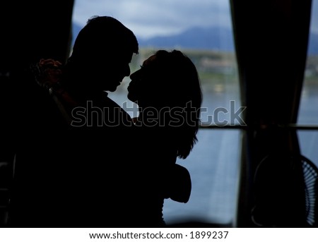 Silhouette of hugging man and woman- room for text at right