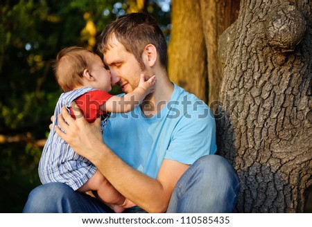 Son kissing his father. Outdoor
