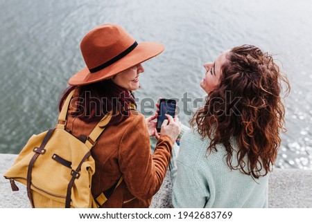 Image, Stock Photo two women sightseeing Porto views by the river and taking picture with mobile phone. Travel and friendship concept