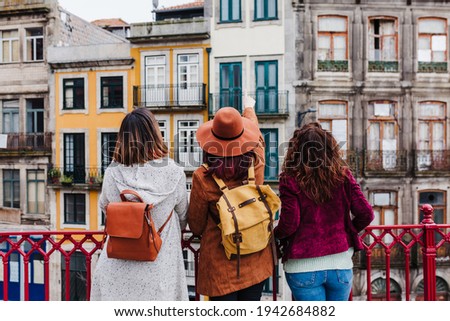 Foto Bild Drei glückliche Freunde bei der Besichtigung der Brücke von Porto bei Sonnenuntergang. Reisen, Freundschaft und Lifestyle