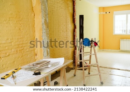 Foto Bild Baupläne, Gehörschutz, Schutzbrille und Werkzeuge am Arbeitsplatz des Architekten auf der Baustelle