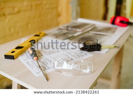 Similar – Foto Bild Baupläne, Gehörschutz, Schutzbrille und Werkzeuge am Arbeitsplatz des Architekten auf der Baustelle