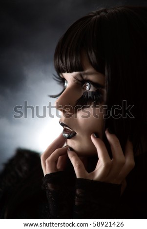 Portrait of strange girl with creative make-up and big feather artificial eyelashes, soft focus